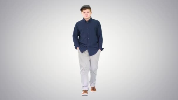 Modny młodzieniec spacerujący z rękami w kieszeniach na gradientowym tle. — Wideo stockowe