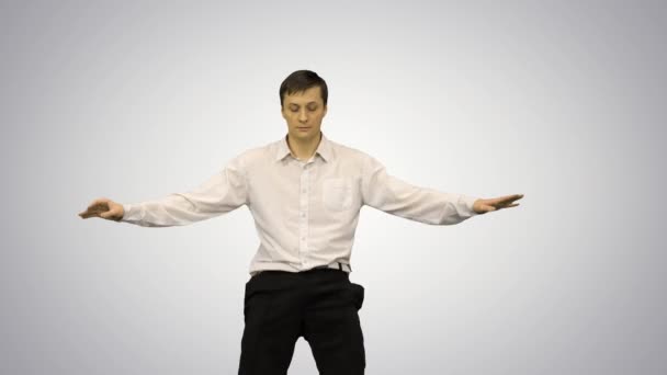 Молодой человек в белой рубашке танцует современный танец с изогнутыми руками на градиентном фоне. — стоковое видео