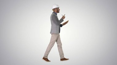 Günlük giysiler ve kalın şapka giyen Arap adam kontrol listesi yazıyor.