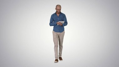 Gradyan üzerinde yürüyen ve tablet sörf interneti kullanan Arap adam