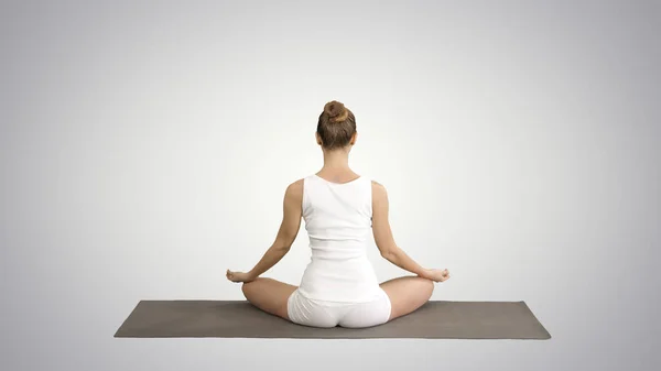 Спокойная красивая женщина делает упражнения йоги сидя в позе йоги на гр — стоковое фото