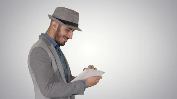 Casual man using tablet and smiling while waking on gradient bac — Stock Photo, Image