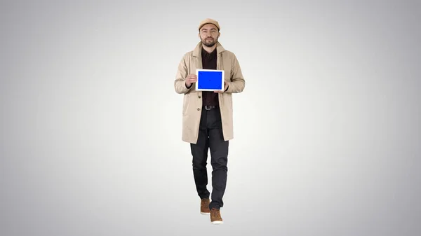 Ελκυστικός άνδρας κρατώντας tablet με μπλε οθόνη κλειδί mockup στο gra — Φωτογραφία Αρχείου