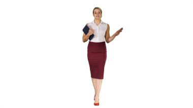Öğretmen beyaz arka planda yürürken kameraya konuşuyor.