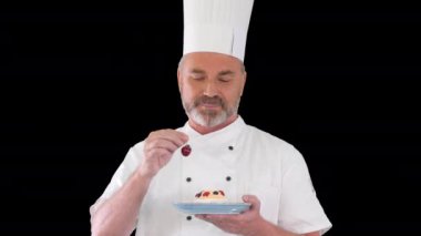 Pastanın üstüne vişne koyan şef. Pastaya krema koymadan önce, Alpha Channel.