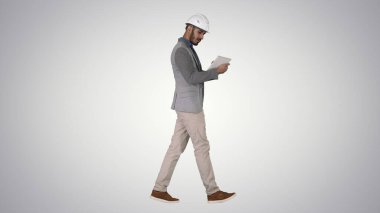 Gradyan arka plan üzerinde yürüyen ve dijital tablet üzerinde çalışan mühendis