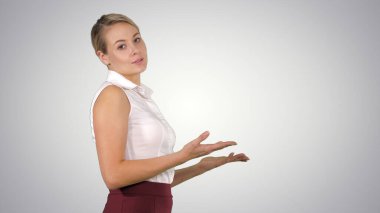 Çekici iş kadını yürüyor ve kameraya konuşuyor.