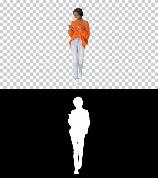 微笑的女人一边走路一边用手机发短信, — 图库照片