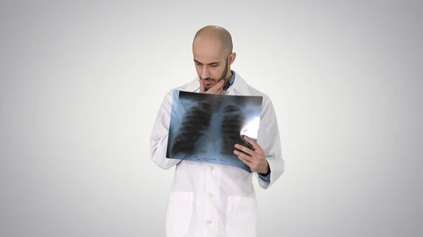 Dokter radioloog kijkt naar röntgenscan lopen op gradiënt bac — Stockfoto