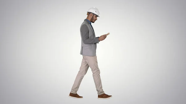 Joven arquitecto leyendo libro de texto o cuaderno mientras camina en gr — Foto de Stock