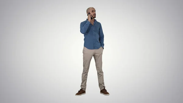Hombre árabe hablando por teléfono en el fondo gradiente. — Foto de Stock