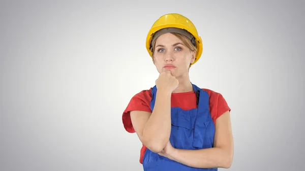Denken bouwvakker vrouw dragen bouwvakker helm op gra — Stockfoto