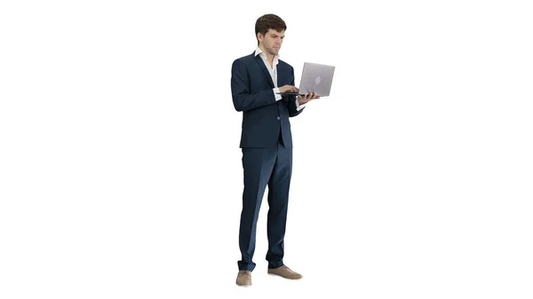 Концентрований молодий бізнесмен працює на ноутбуці, стоячи — стокове фото