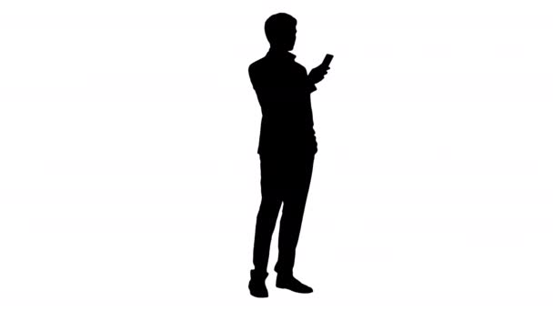 Silhouette Serious hombre de negocios mirando su teléfono. — Vídeo de stock