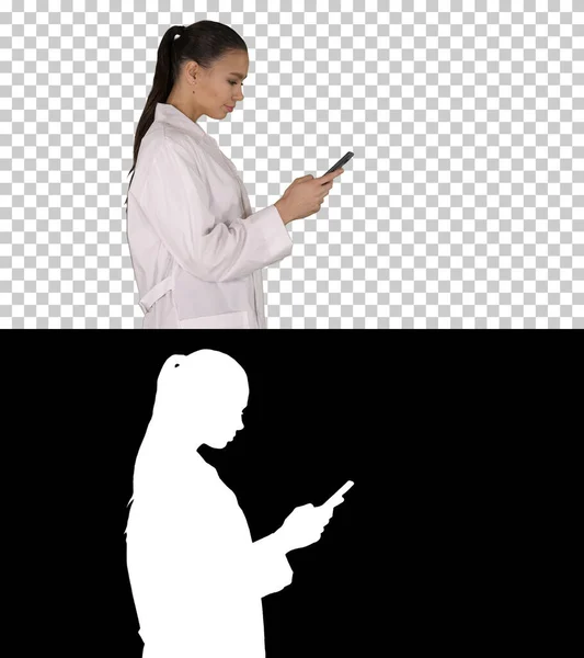 Wesoły słodkie młoda kobieta lekarz wpisując tekst na telefon podczas spaceru — Zdjęcie stockowe