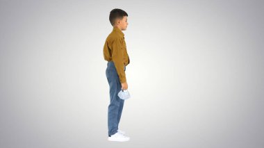 Küçük çocuk maskesini çıkarıyor ve kameraya gülümsüyor.