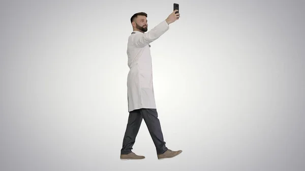 Dottore scattare un selfie con smartphone mentre si cammina sul gradiente — Foto Stock