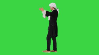 Wolfgang Amadeus Mozart gibi giyinmiş bir adam yeşil ekranda orkestra yönetiyor, Chroma Key.