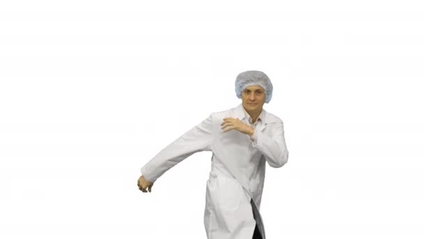 Jonge mannelijke arts in witte badjas en beschermende pet dansen moderne dans kijken naar camera op witte achtergrond. — Stockvideo