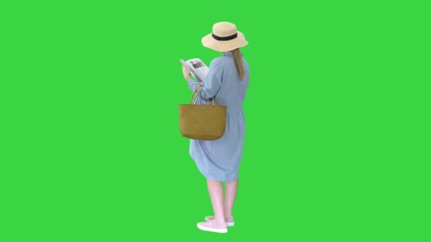 Mulher grávida em um chapéu de verão leitura revista em uma tela verde, Chroma Key. — Vídeo de Stock