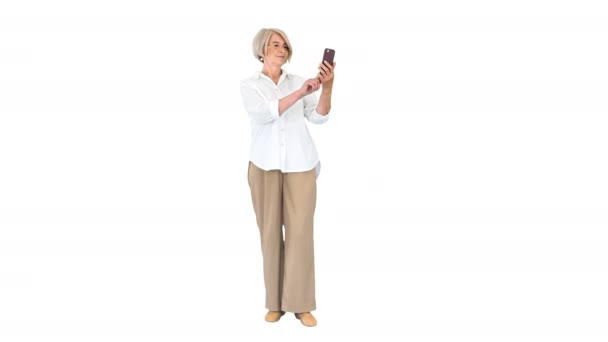 Inteligente abuela tomando un selfie sobre fondo blanco. — Vídeos de Stock