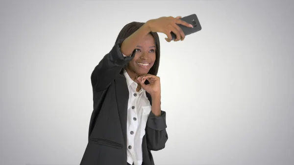 Pretty african amerivan female making selfie on her phone on gra — Stock Photo, Image