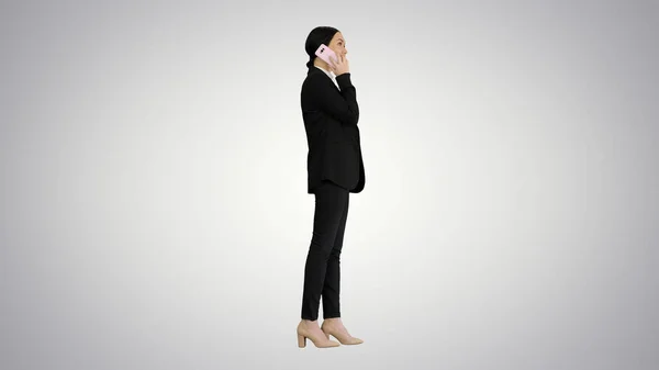 Joven empresaria hablando por teléfono en un fondo degradado. — Foto de Stock