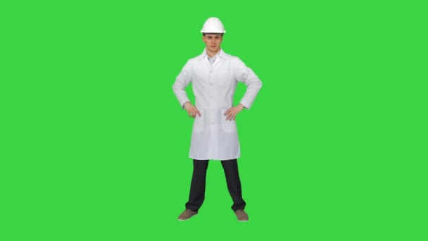 Um jovem engenheiro colocando chapéu de alvoroço em uma tela verde, Chroma Key. — Vídeo de Stock