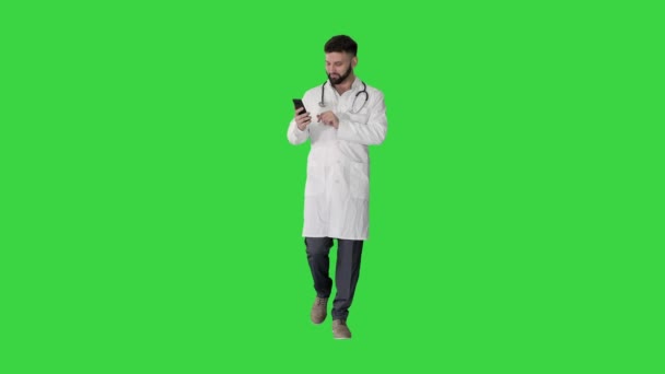Gülümseyen olgun doktor akıllı telefon kullanıyor ve yeşil ekranda gülüyor, Chroma Key. — Stok video