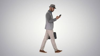 Sıradan bir adam telefonda mesajlaşıyor ve değişken bir arkaplanda yürüyor..
