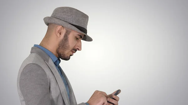 Schwerwiegender arabischer Gelegenheitsmann benutzt Smartphone beim Gehen — Stockfoto
