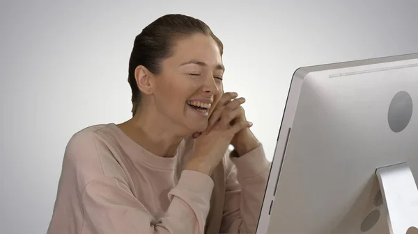 Kobieta ogląda filmy na komputerze i śmieje się na gradientowym backg — Zdjęcie stockowe