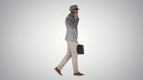 Árabe hombre en casual caminar y hacer una llamada telefónica en gradiente —  Fotos de Stock