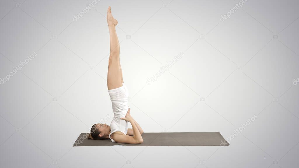 Woman practicing yoga, standing in salamba sarvangasana exercise