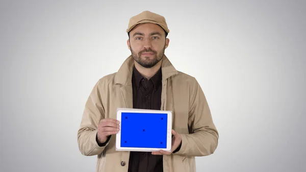 Man walking i trzymając tabletkę z niebieskim ekranem makieta na Gradie — Zdjęcie stockowe