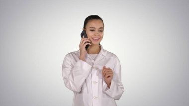 Gülümseyen bayan doktor mezuniyet töreninde konuşurken telefonda konuşuyor.