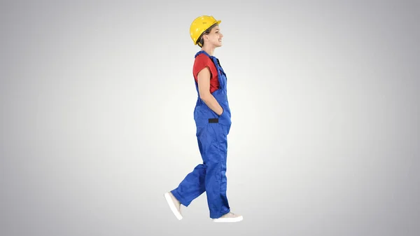 Bauarbeiterin läuft mit den Händen in den Taschen auf Gefällstrecke — Stockfoto