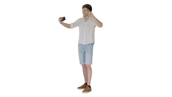 Young man in casual white shirt taking selfies on his phone on w — Stock Photo, Image