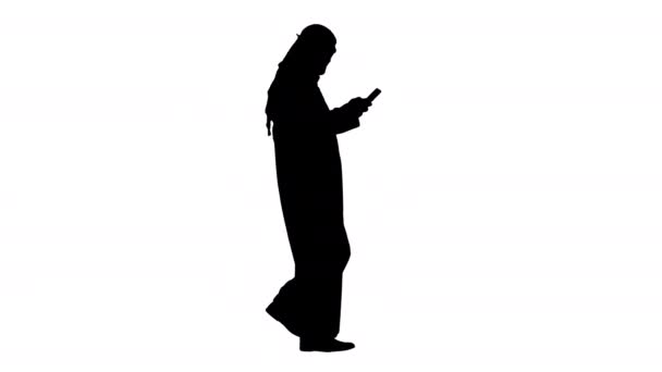 Арабська людина використовує смартфон серфінг в Інтернеті або повідомлення під час ходьби Альфа Канал — стокове відео