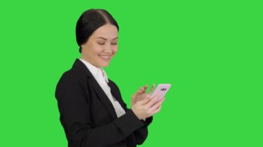 Gülümseyen iş kadını, yeşil ekranda resimlerini kontrol ediyor, Chroma Key.