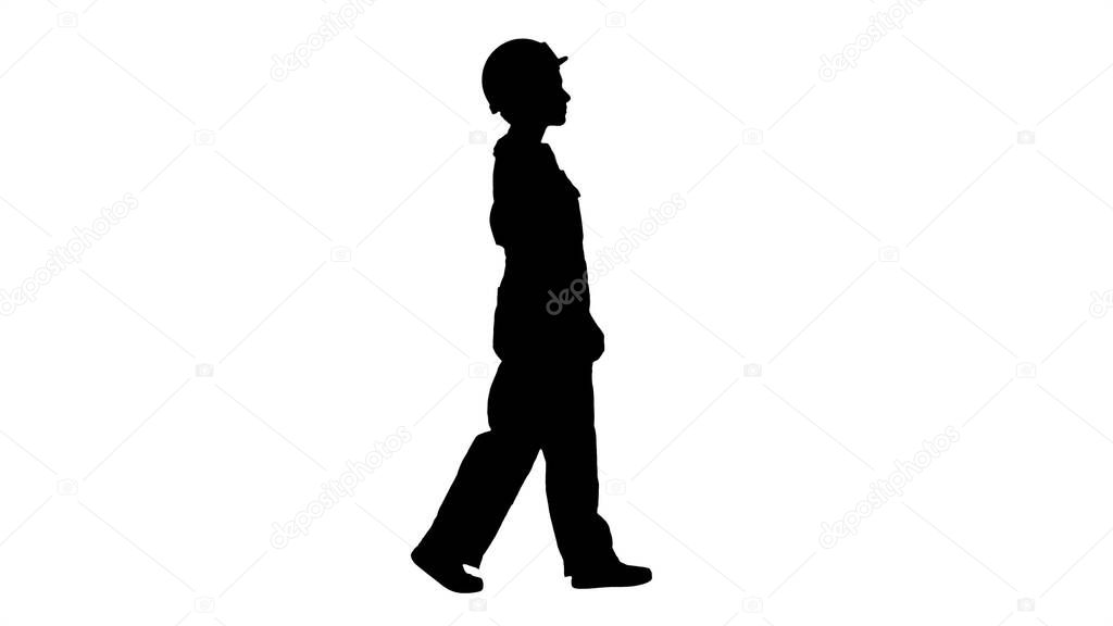 Silhouette Young woman construction worker in yellow hardhat wal