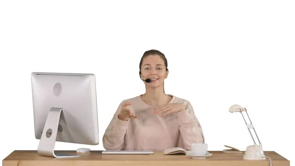 Mujer joven feliz en auriculares mirando a la cámara y hablando sobre fondo blanco. — Foto de Stock