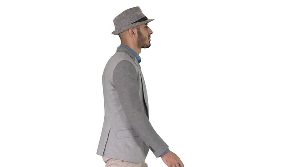 Uomo arabo casual in cappello che cammina su sfondo bianco. — Foto Stock