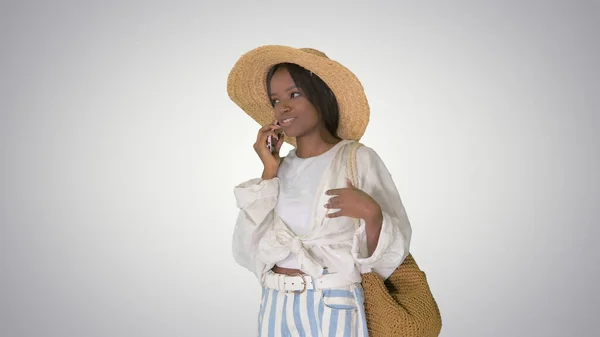 Bastante joven afroamericana mujer en un sombrero de paja hablando en él — Foto de Stock