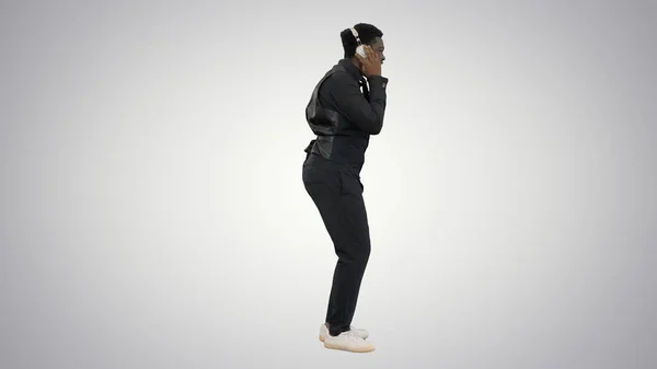Africký Američan drží sluchátka oběma rukama a groo — Stock fotografie