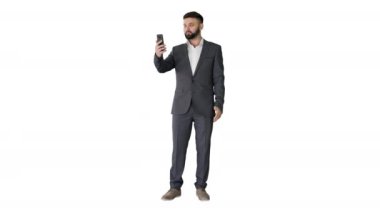 Yakışıklı Türk işadamı beyaz arka planda akıllı telefonuyla video görüşmesi yapıyor..