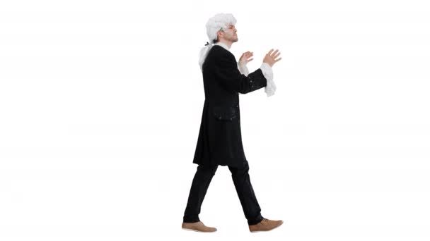Άντρας ντυμένος σαν τον Μότσαρτ να διευθύνει ενώ περπατάει σε λευκό φόντο. — Αρχείο Βίντεο