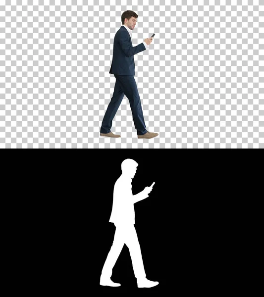 Vážný podnikatel používající telefonní hlasové vytáčení při chůzi, Alpha — Stock fotografie