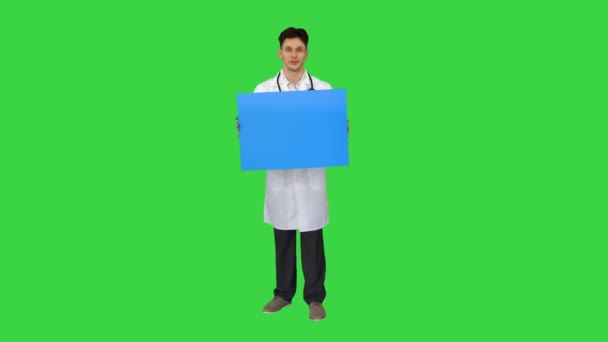 Glücklich lächelnder Arzt zeigt leeres Schild und tanzt auf einem Green Screen, Chroma Key. — Stockvideo