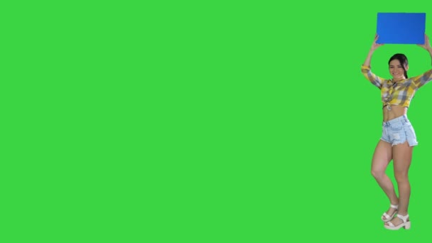 Menina com uma placa vazia anunciando nova rodada em uma tela verde, Chroma Key. — Vídeo de Stock